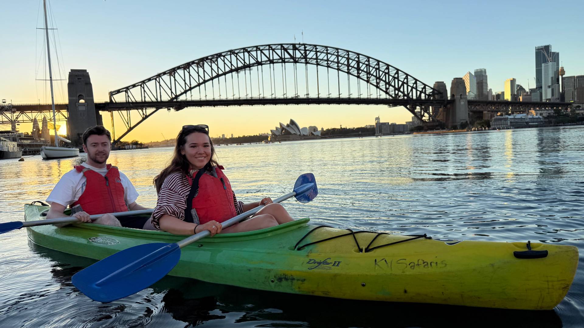 Couple kayaking on Sydney Harbour with bridge background