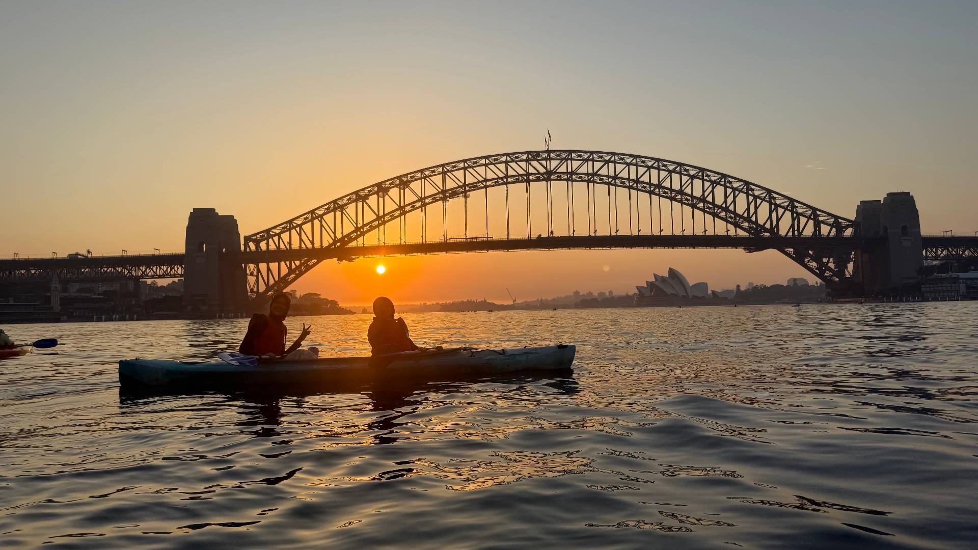 Couple enjoying sunset kayak tour Sydney Harbour