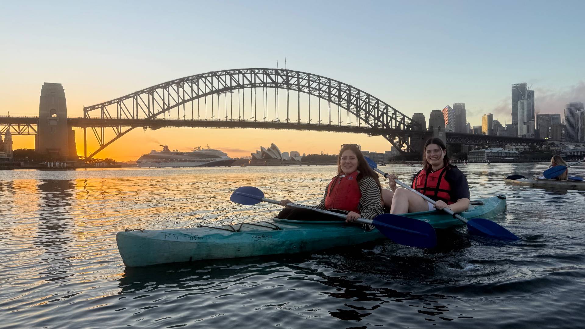 Friends kayaking with Sydney Harbour Bridge view