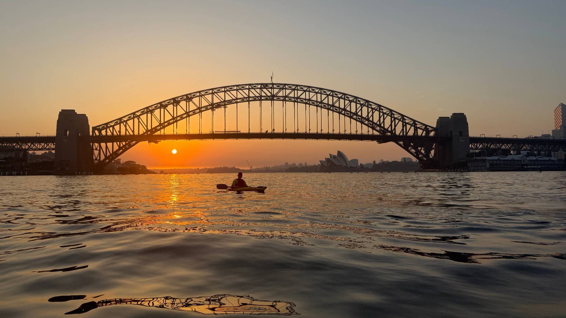 Sunrise kayak tour Sydney – solo paddler with Harbour Bridge views