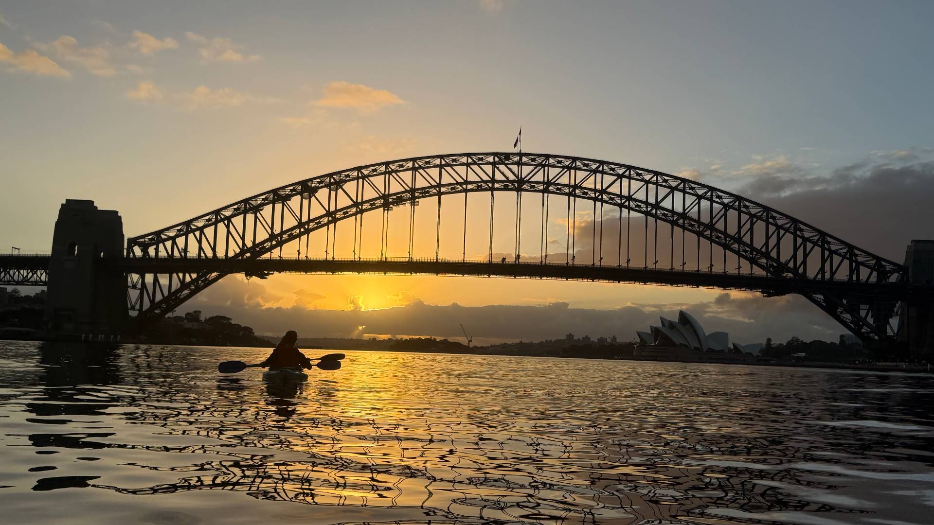Solo kayaker silhouette on Sydney Harbour at sunset
